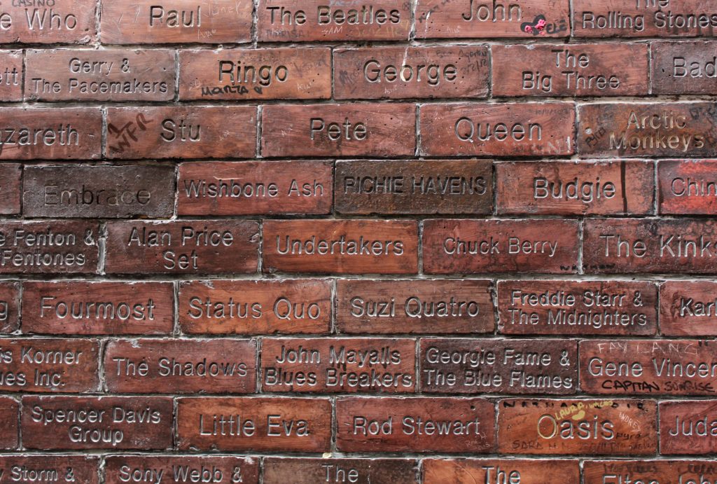 Parede de tijolos em Liverpool com nomes de bandas e cantores famosos