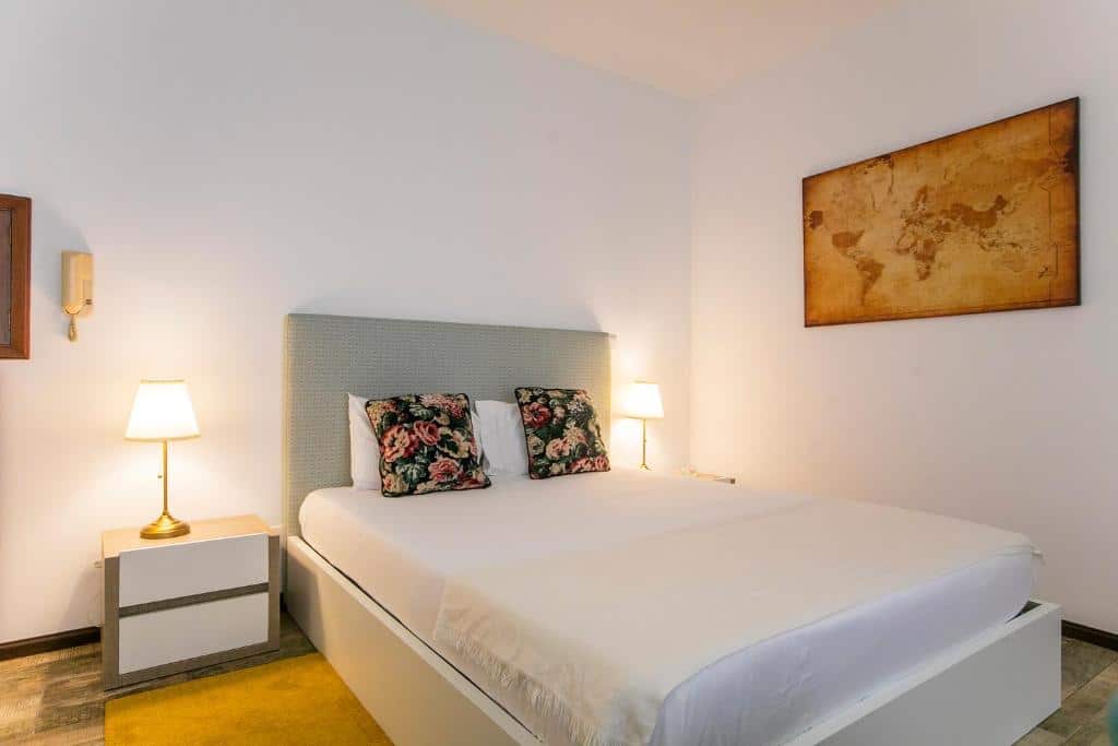 Quarto da Casa de Cristal, com cama de casal ao centro e duas mesas de cabeceira com candeeiro.