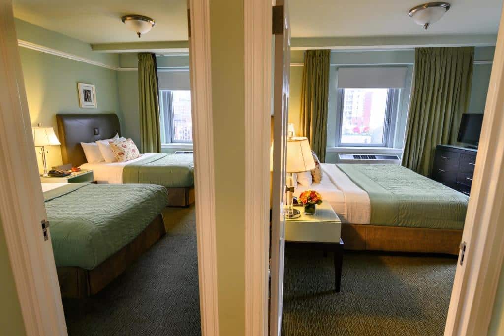 Dois quartos comunicantes do Hotel Beacon, cada um com uma cama de casal grande e decoração em tons de verde. Ambos têm janelas amplas, com luz natural e vista para a cidade.