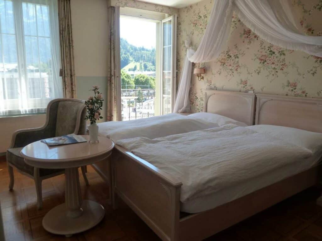 Quarto do Hotel Central Continental com cama de casal e porta para a varanda.