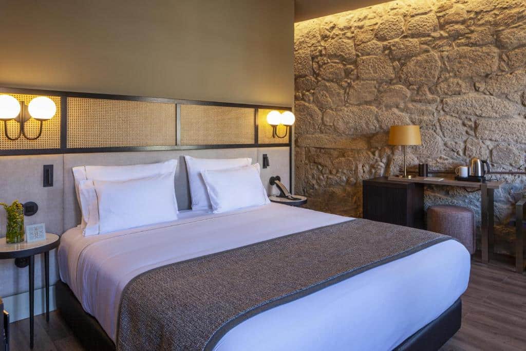 Quarto do Hotel das Virtudes com cama de casal e mesinhas de cabeceira de cada lado.