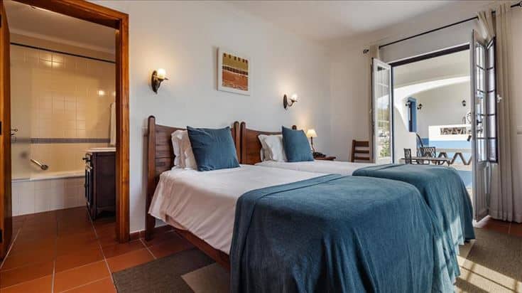 Quarto com duas camas de solteiro e casa de banho com banheira na Vila Planície, em Monsaraz
