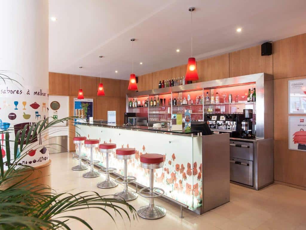Bar do Hotel ibis Porto Sao Joao balcão do lado esquerdo com  bancos em frente ao balcão.