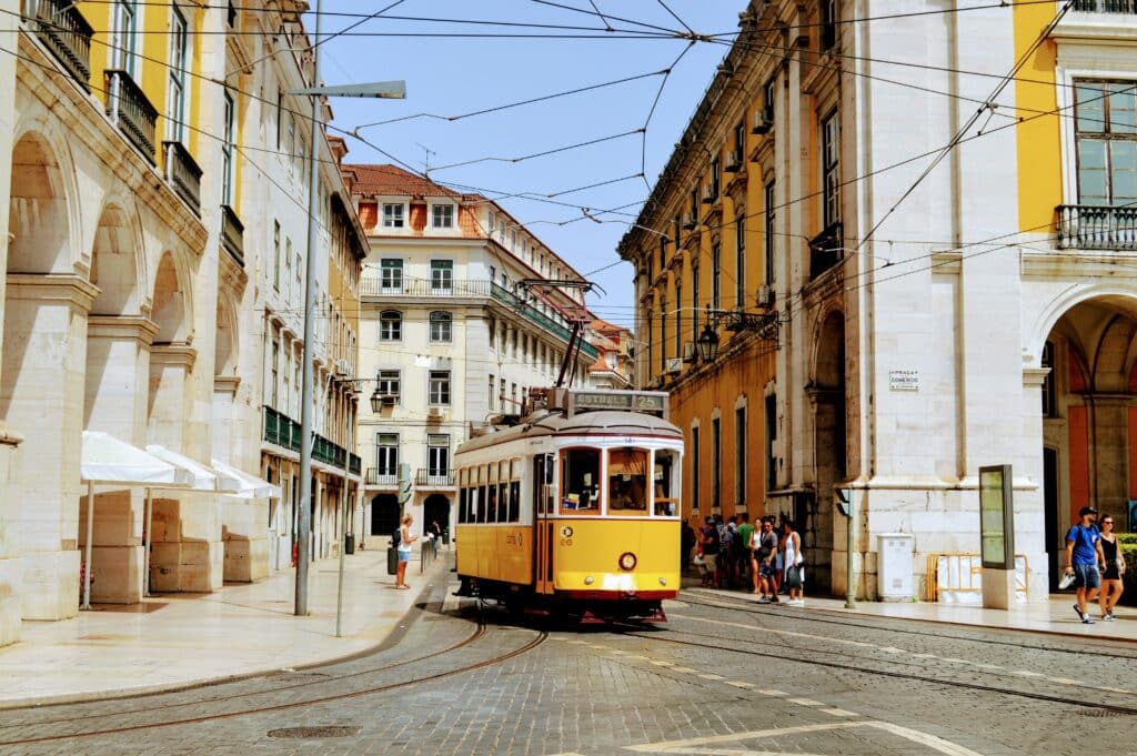 Elétrico a circular nas ruas de Lisboa, durante o dia.