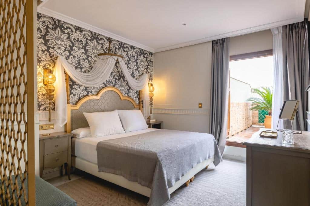 Quarto do Hotel Gravina 51 com cama de casal ao centro, sob um arco, e uma cómoda de cada lado.