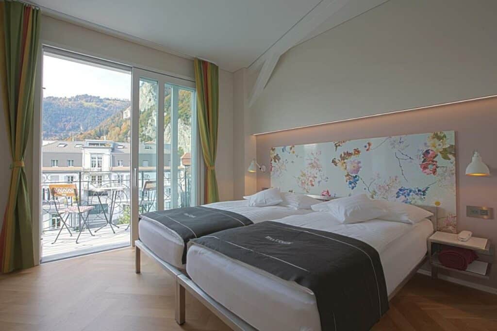 Quarto do Boutique Hotel Bellevue com cama de casal e porta de acesso à varanda.