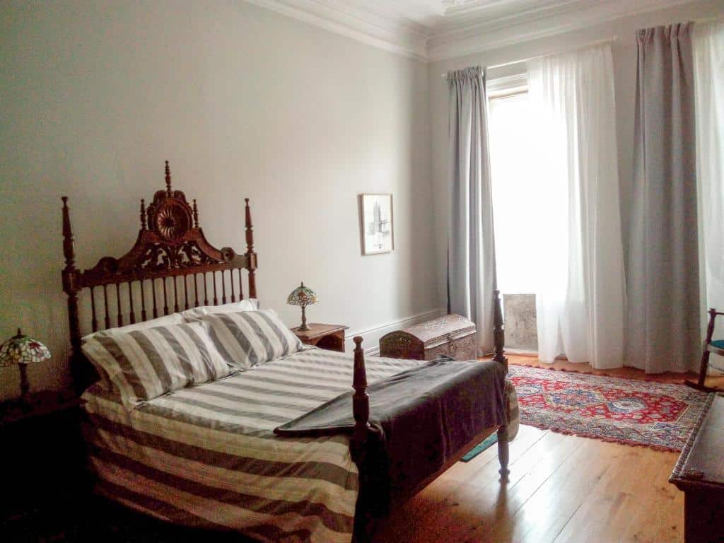 Quarto da Casa Familiar do Porto, com cama de casal à esquerda e duas mesas de cabeceira com candeeiro.