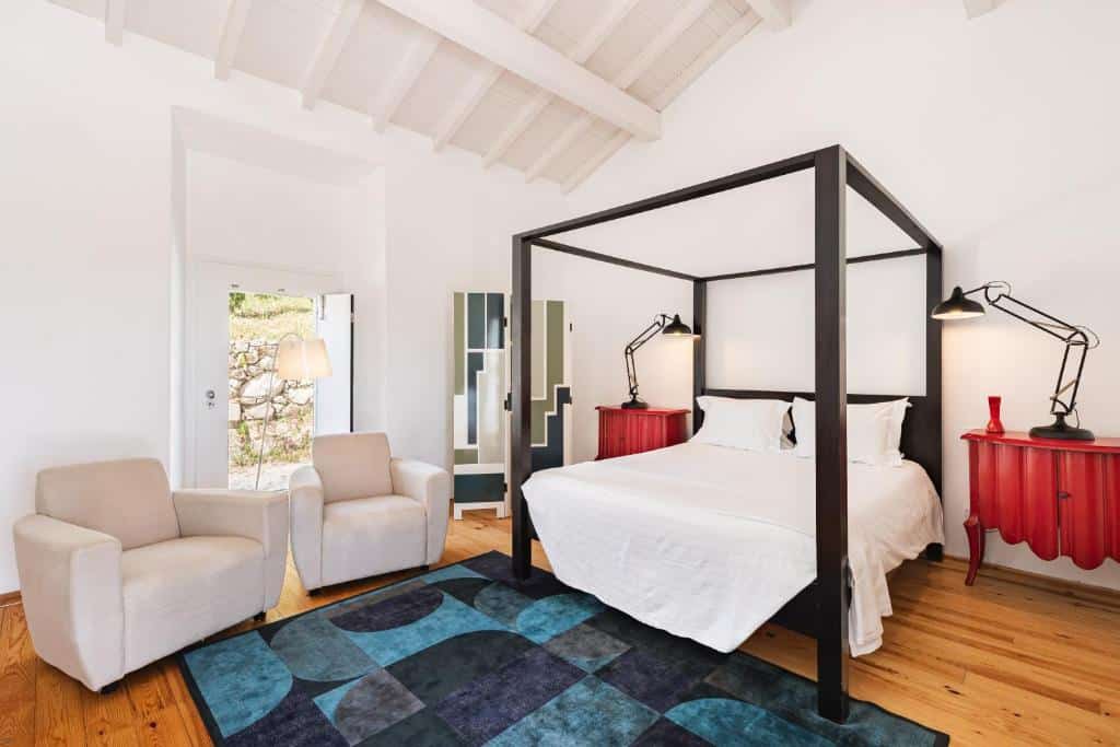 Quarto do Imani Country House com cama de casal, móveis vermelhos com candeeiros e porta para o jardim