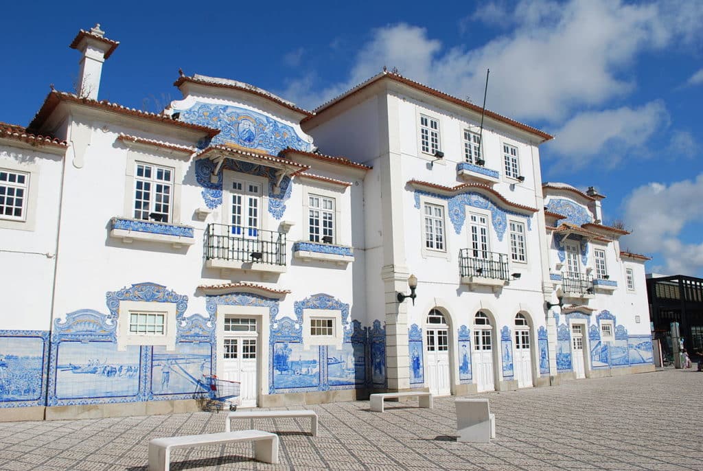 Fachada da antiga estação ferroviária de Aveiro, revestida a painéis de azulejos azuis.