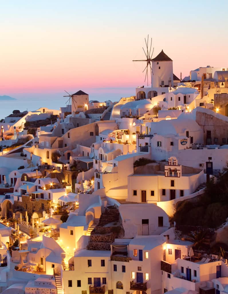 Casinhas em Oia e um céu multicolorido ao fundo