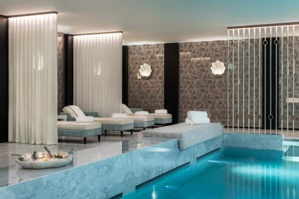 Piscina interior do Maison Albar Hotels Le Monumental Palace, com cadeiras ao lado.