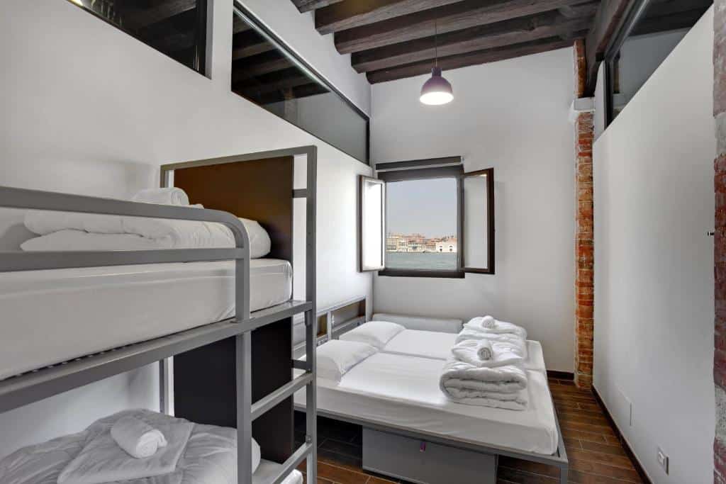 Quarto acolhedor com beliches e janela com vista para a baía de Veneza