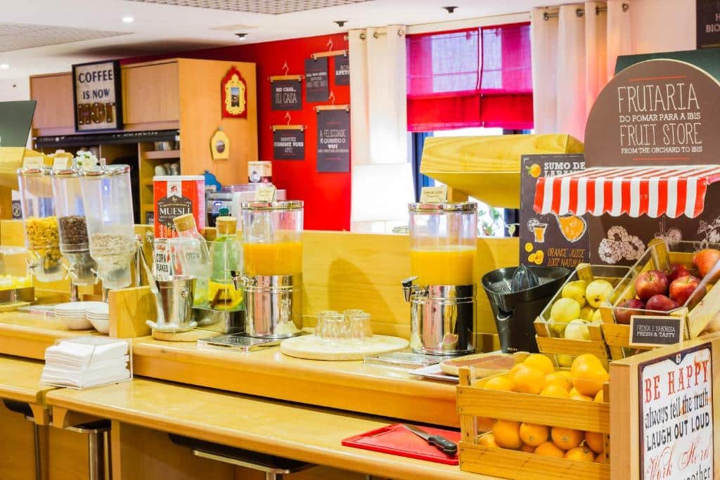 Mesa de pequeno-almoço do ibis Porto Centro São Bento com muitas frutas e sucos.