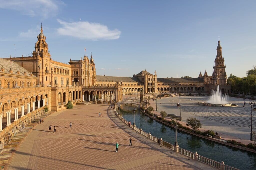Plaza de España, no Parque de María Luisa, em Sevilha, com o palácio à esquerda e o lago à direita.