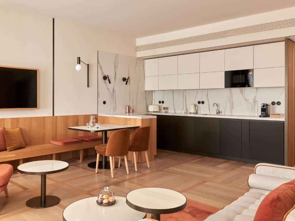 Cozinha moderna e zona de estar do The Julius Prague, com bancos embutidos, mesa de jantar, armários e revestimento em mármore.