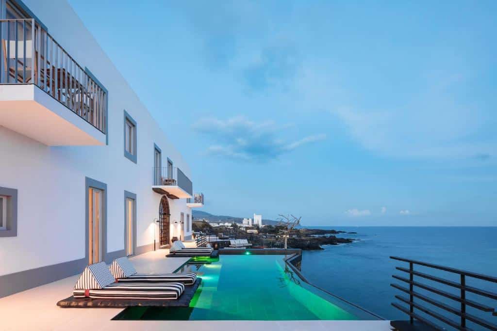 Piscina exterior do White Exclusive Suites & Villas, com vista para o mar.