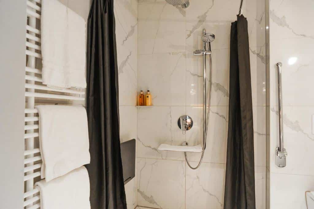 Casa de banho adaptada do Boutique Hotel Glacier, com chuveiro e barra de apoio.