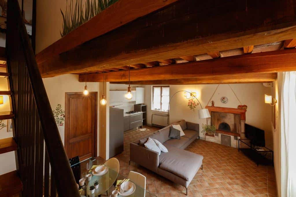 Sala de estar integrada com cozinha numa casa de campo com decoração rústica e mobiliário confortável