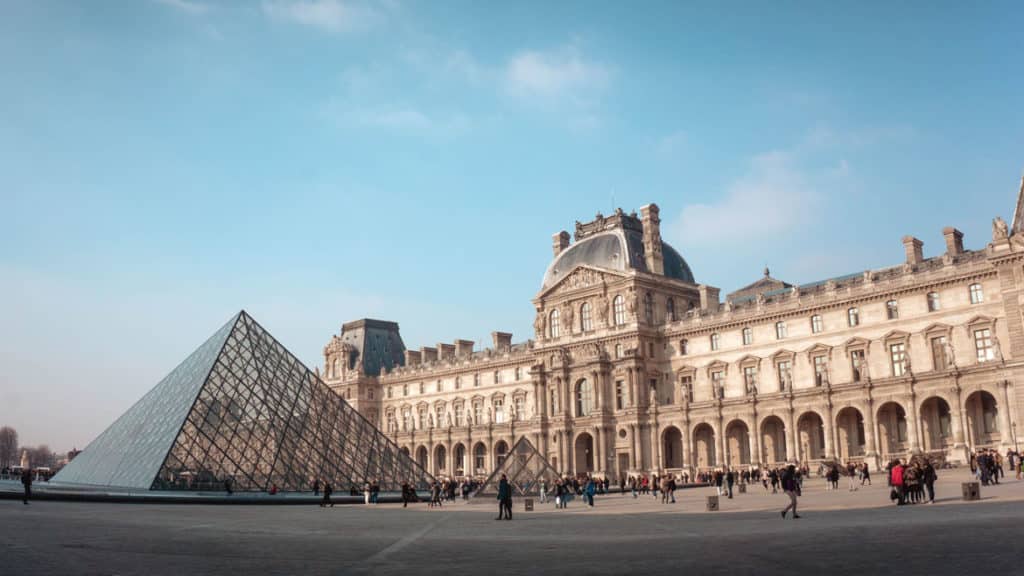 Museu do Louvre visto do exterior, com a pirâmide de vidro e o edifício antigo ao fundo