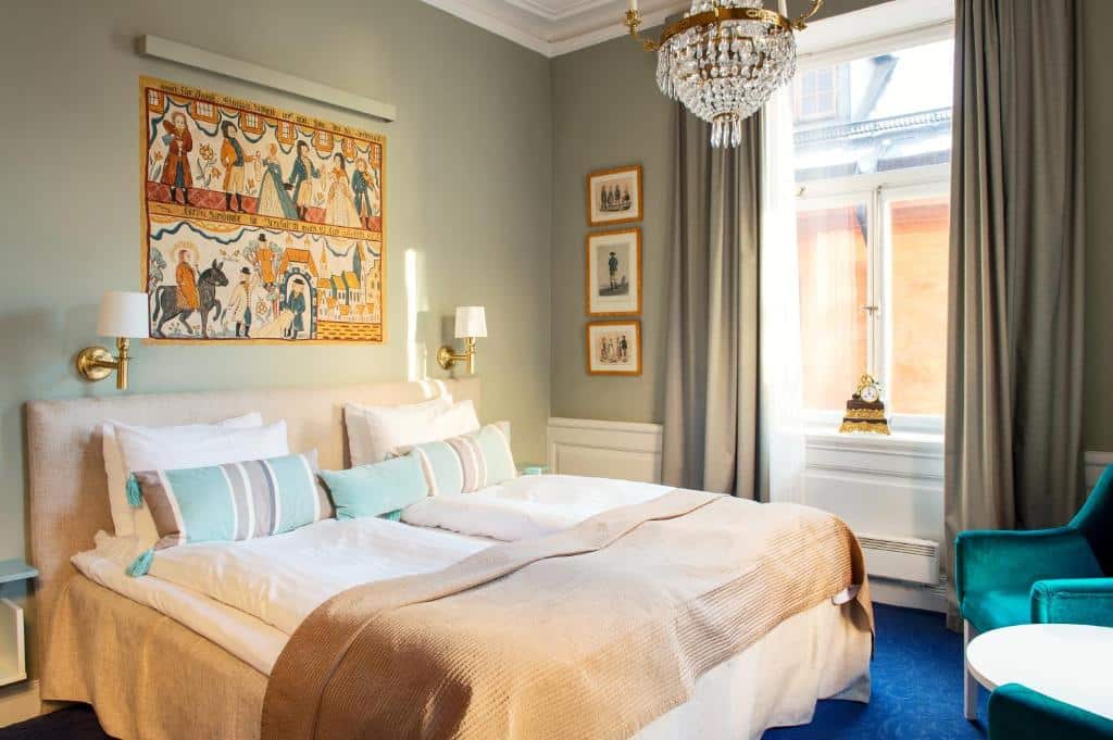 Quarto do Lady Hamilton Hotel com cama de casal e uma poltrona.
