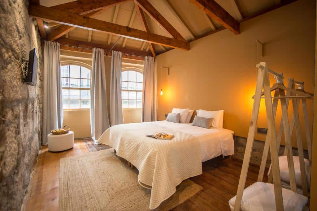Quarto da Laurear Guest House com cama de casal e, em frente, uma TV na parede.