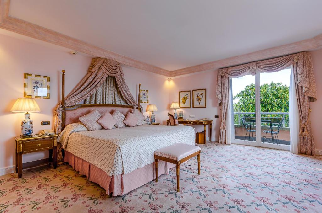 Quarto do Olissippo Lapa Palace, com cama de casal, mesas de cabeceira e secretária.