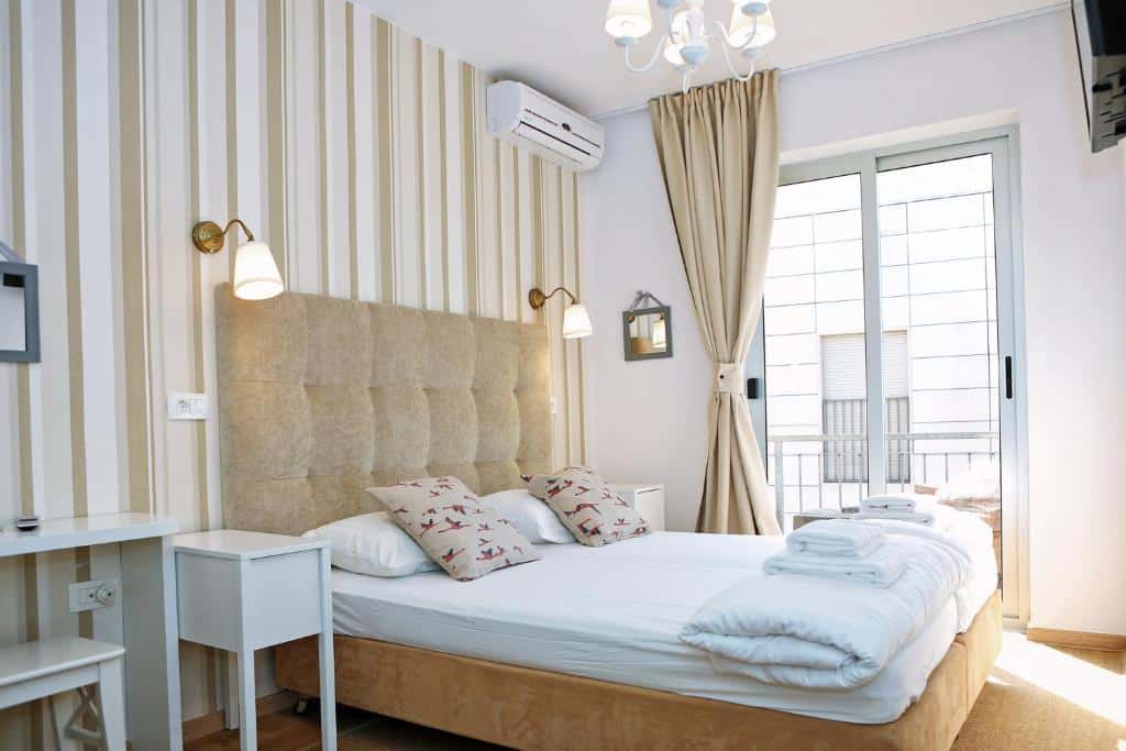 Quarto de hotel confortável com cama de casal, ar condicionado e decoração em tons de bege e branco, no Hotel Delfin, em Diklo