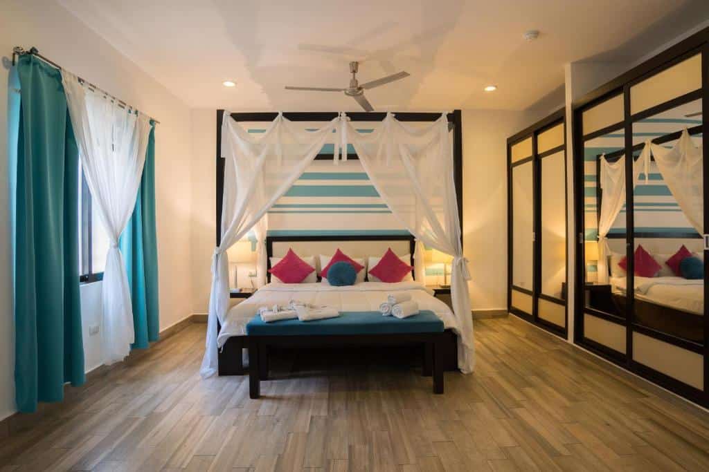 Quarto do Posada Mariposa Boutique Hotel com cama de casal com mosquiteiro branco ao centro. Uma janela fica ao lado da cama.