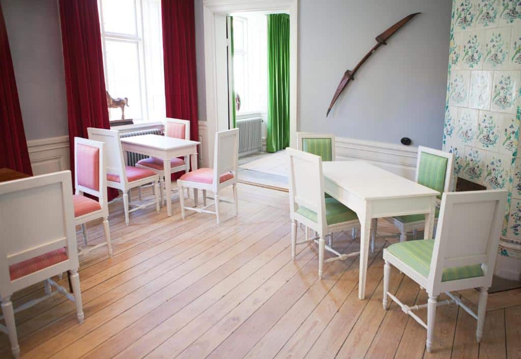 Sala de refeições do Hotel Hellstens Malmgård com mesas e cadeiras.