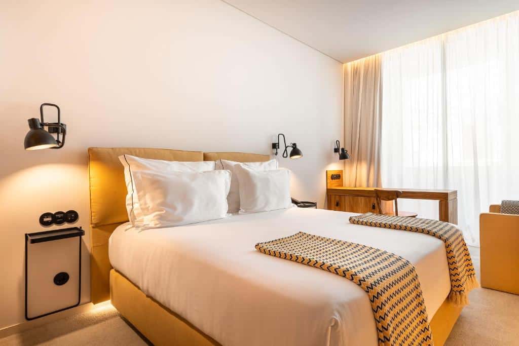 Quarto do 3HB Faro com cama de casal e secretária.