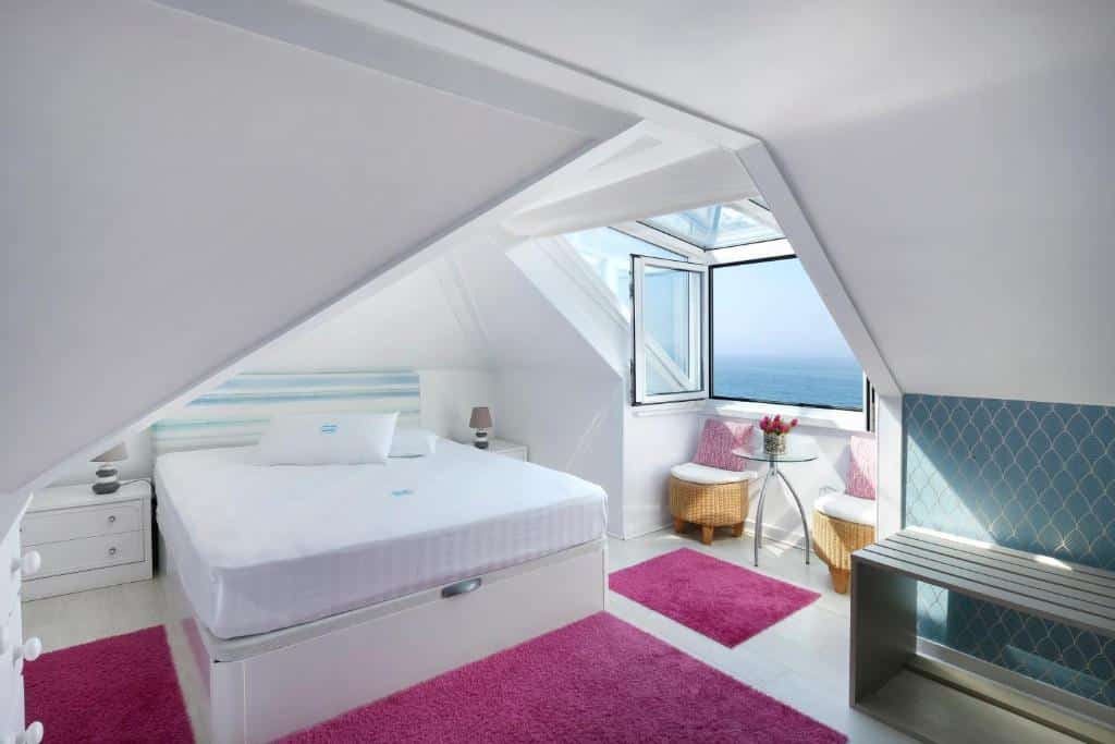 Quarto do Casal Santa Virginia com janela ampla com vista direta para o mar e cama de casal