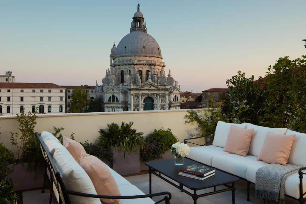 Bela cúpula da Basílica de Santa Maria della Salute, ícone de Veneza, vista de um pátio com sofás e mobiliário de jardim em primeiro plano