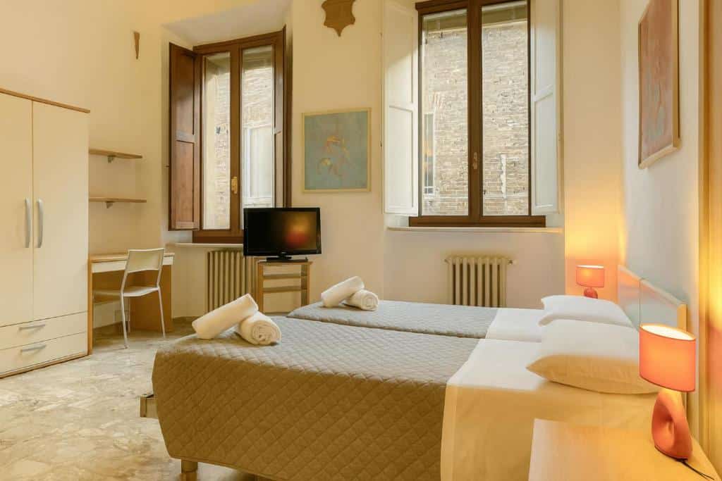 Quarto acolhedor com cama de casal, roupeiro e secretária em decoração clássica