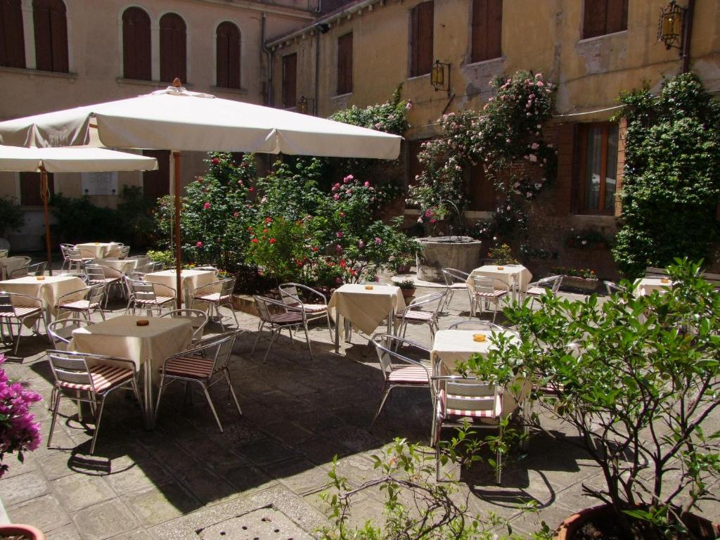 Esplanada de um café numa praça, com toldos e vasos de flores ornamentais
