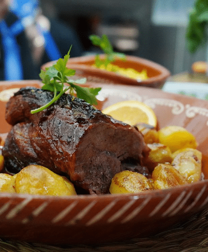 Prato de carne assada da Cozinha do Manel, servido com batatinhas e guarnecido com um raminho de salsa.