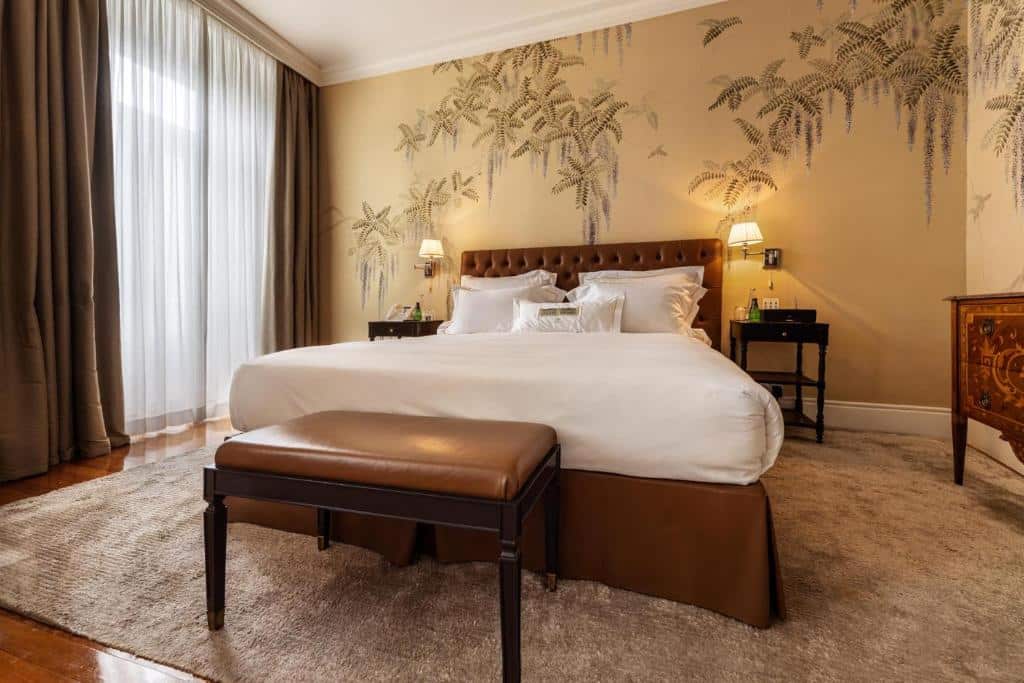 Quarto do Vidago Palace com cama de casal e banco estofado aos pés da cama.