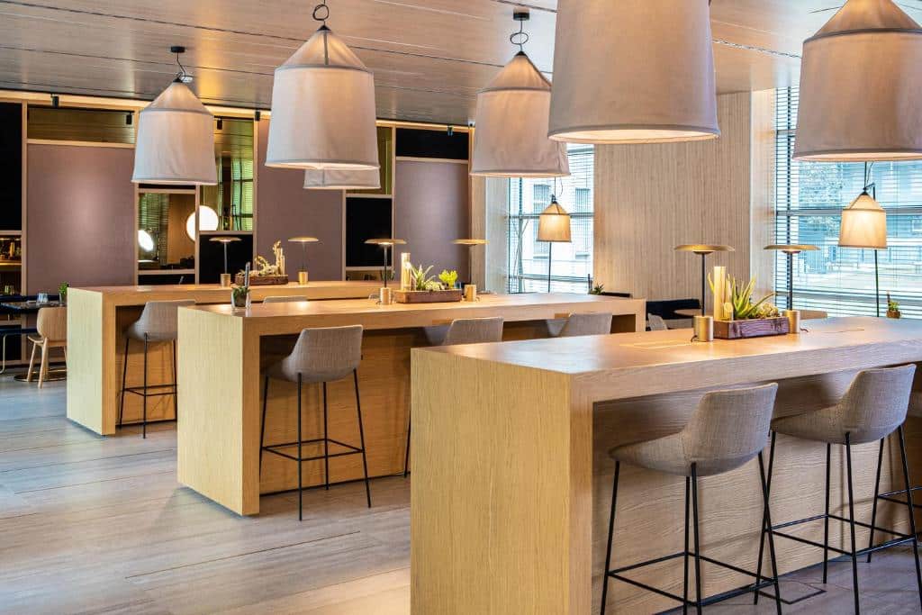 Bar de estilo lounge com três balcões altos e candeeiros em tons de palha no INNSiDE by Meliá Milano Torre GalFa