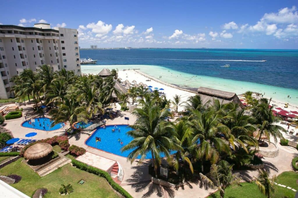 Vista aérea do Hotel Casa Maya com piscina, rodeado de árvores e com vista para o mar, junto à praia