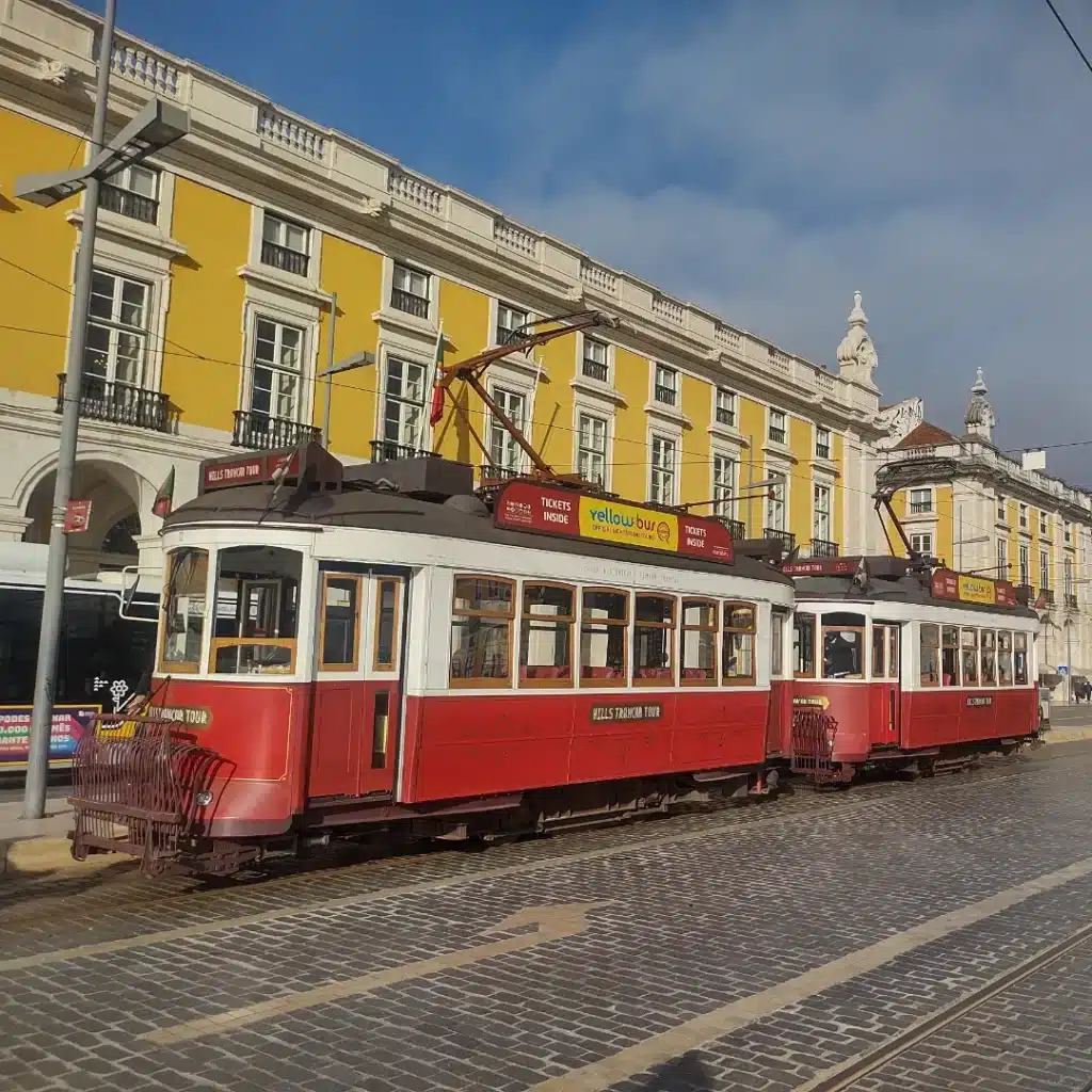 Praça do Comércio, em Lisboa, com um elétrico ao centro e um edifício histórico ao fundo