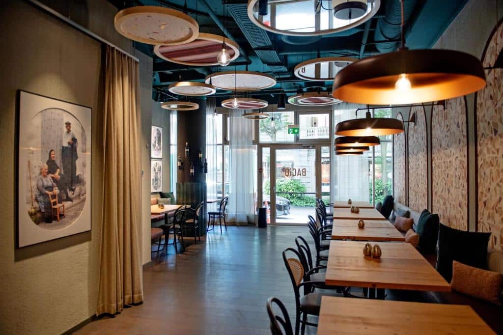 Restaurante do AMERON Luzern, com iluminação quente, mesas de madeira e ambiente acolhedor.