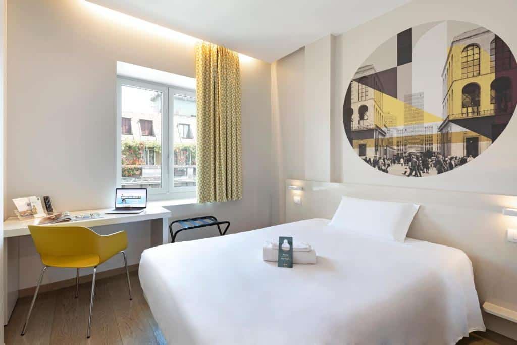 Quarto do B&amp;B Hotel Milano Central Station com uma janela com cortinas, uma secretária com uma cadeira e uma cama de casal