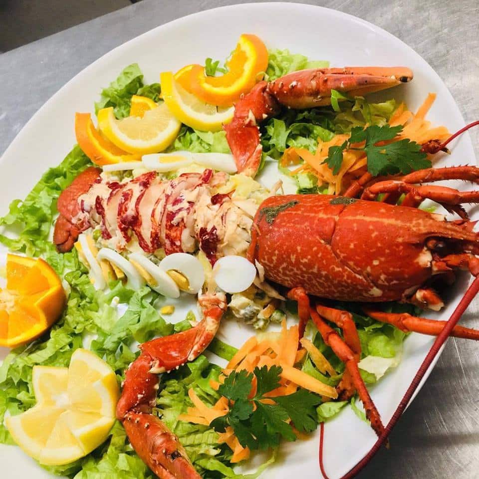 Prato com lagosta, ovos, laranja e salada, servido no restaurante Maré Cheia.