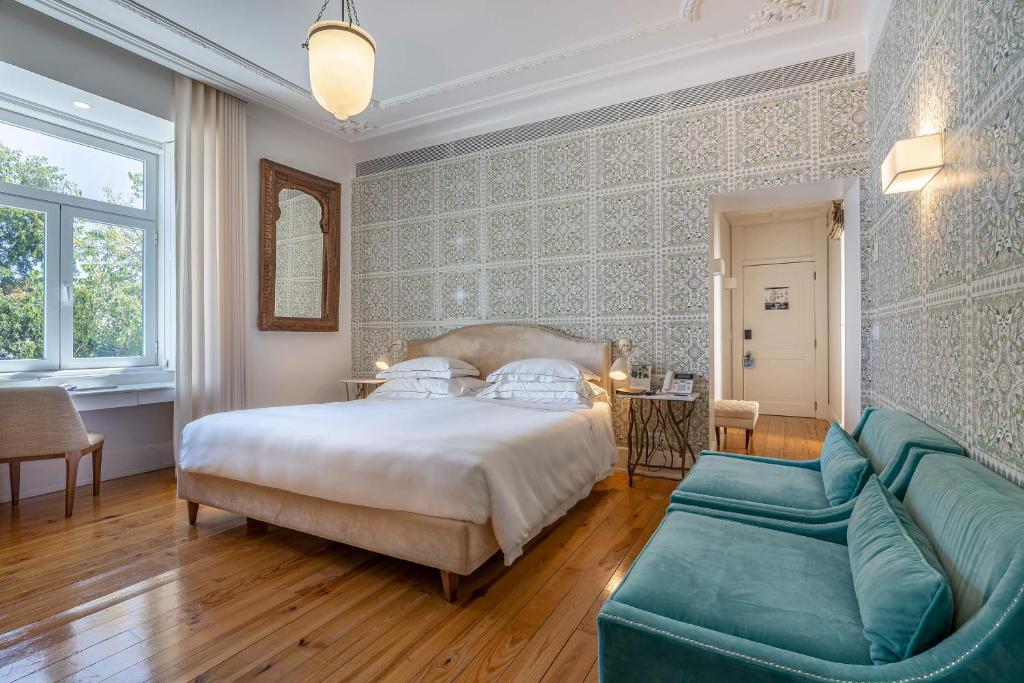 Quarto do Santiago de Alfama – Boutique Hotel, com cama de casal ao centro e cadeirões.