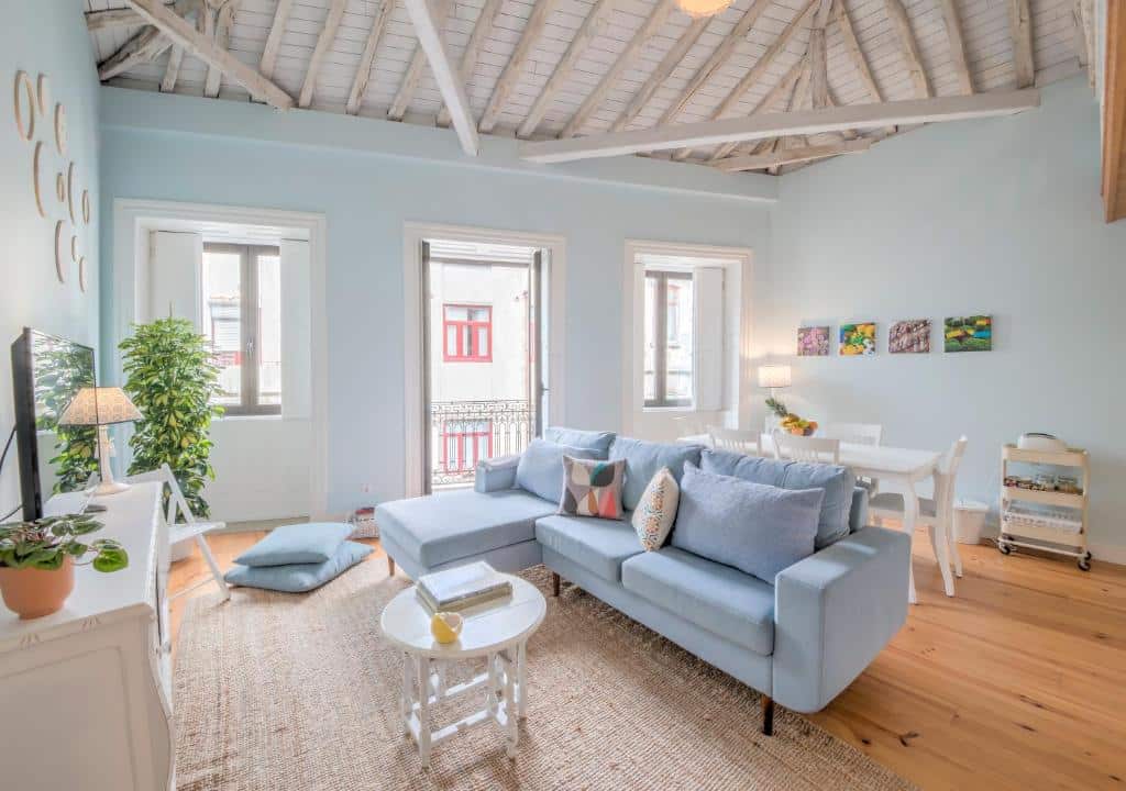 Sala do Look At Me – Serviced Lofts & Studios com sofá azul-claro e mesa de centro branca.