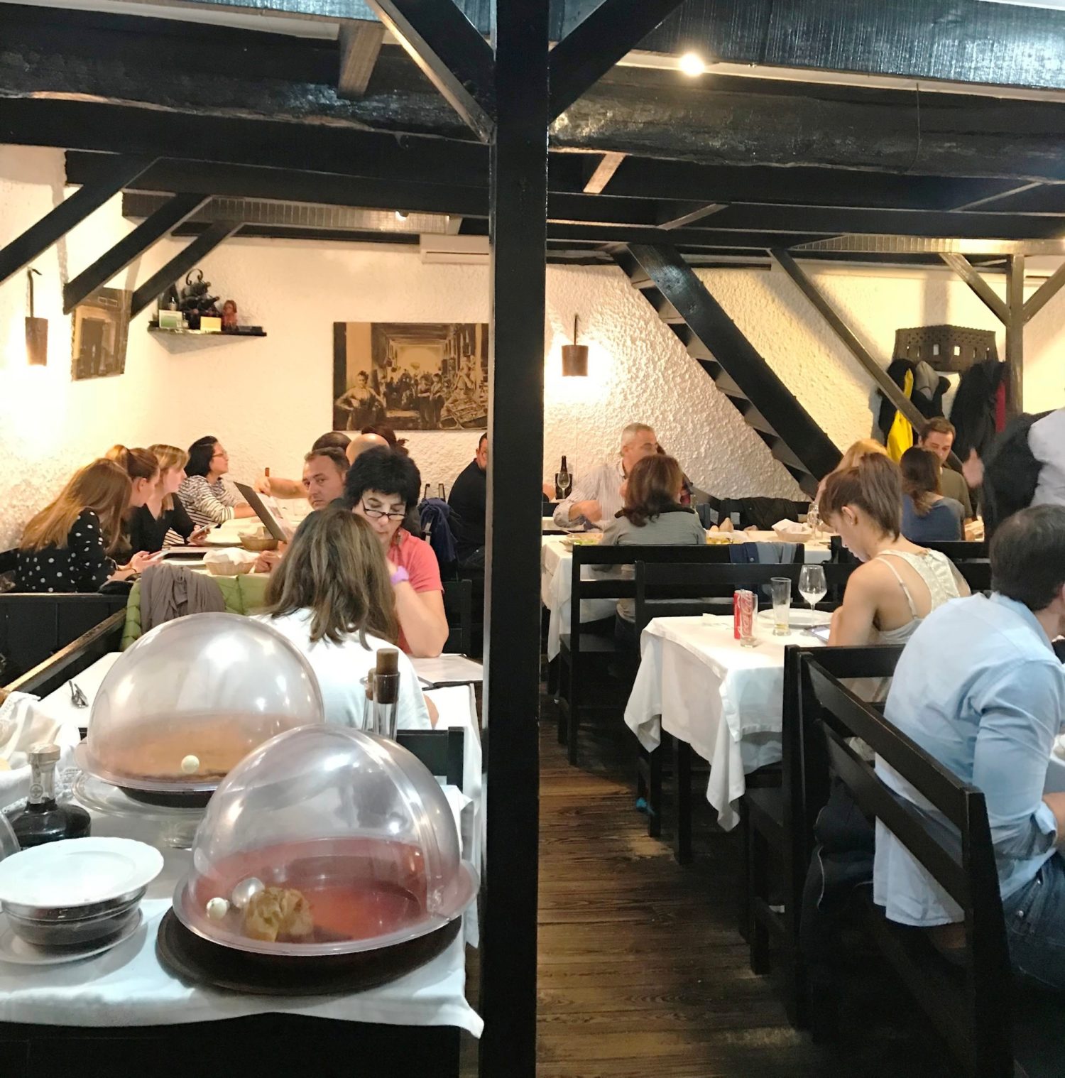 Sala de jantar d'A Tasquinha com várias mesas e pessoas sentadas.