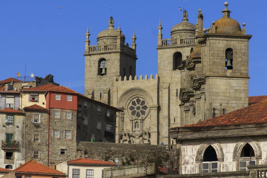 Sé do Porto durante o dia, com casas em frente e a catedral ao fundo.