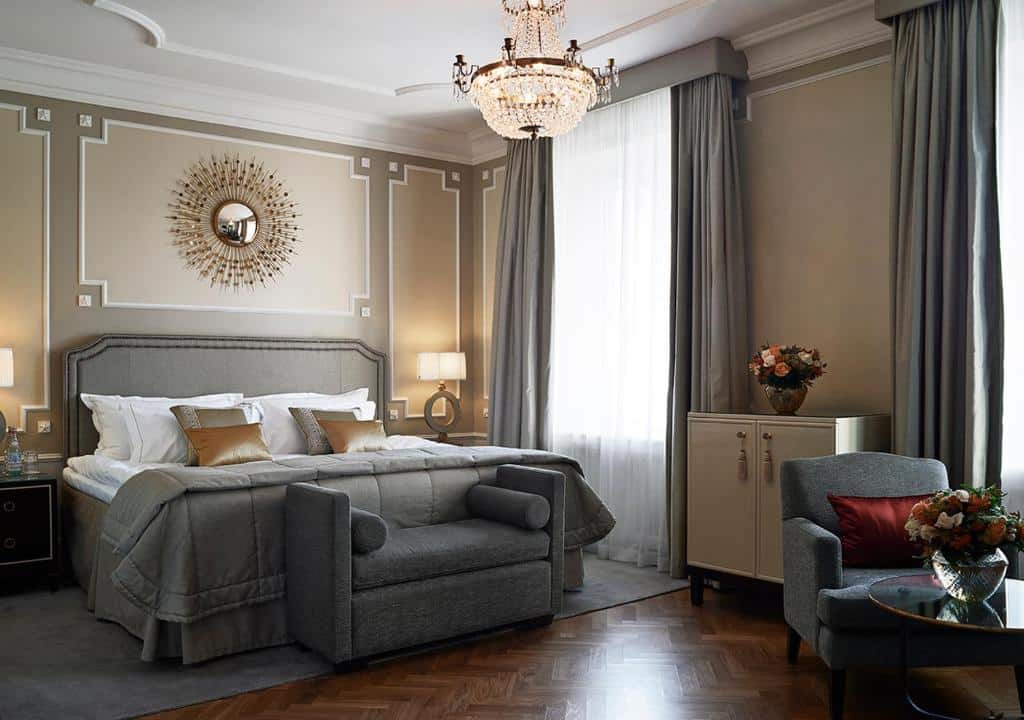 Quarto do Grand Hôtel Stockholm com cama de casal, cómodas com candeeiros e uma poltrona com mesa redonda.