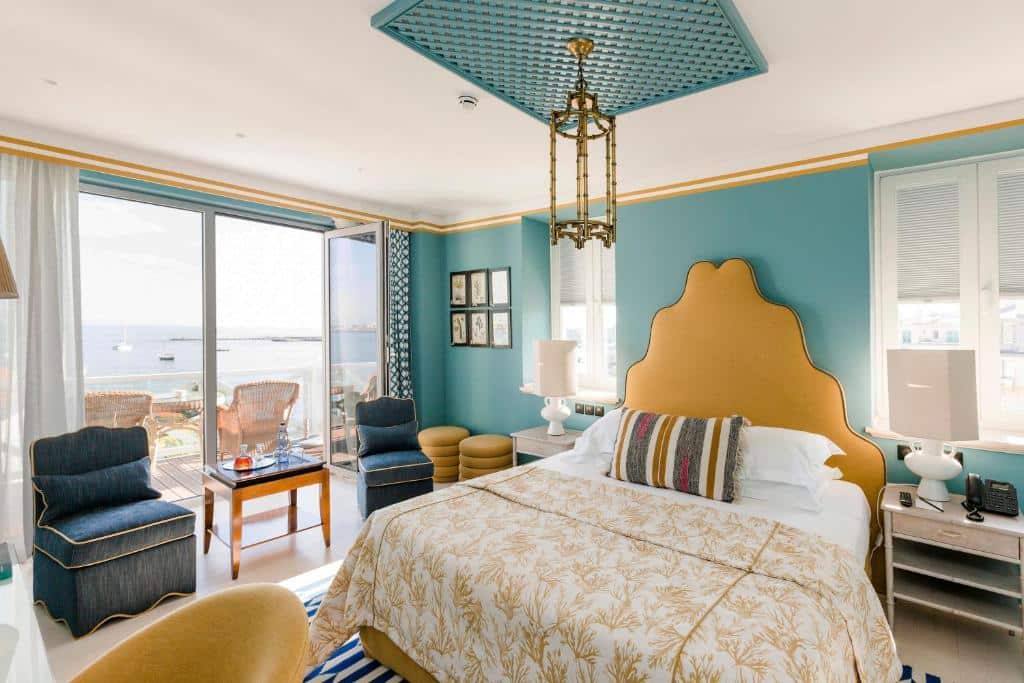 Quarto deluxe do The Albatroz Hotel com cama de casal e varanda com vista de frente para o mar