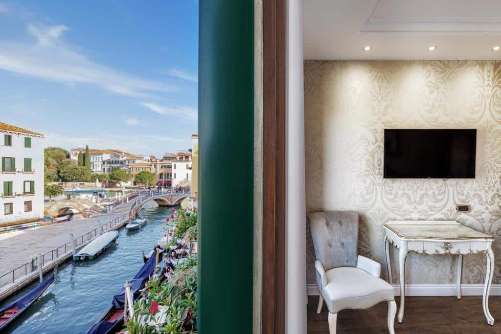 Edifícios históricos, barcos e um canal numa cidade italiana típica, com uma ponte próxima