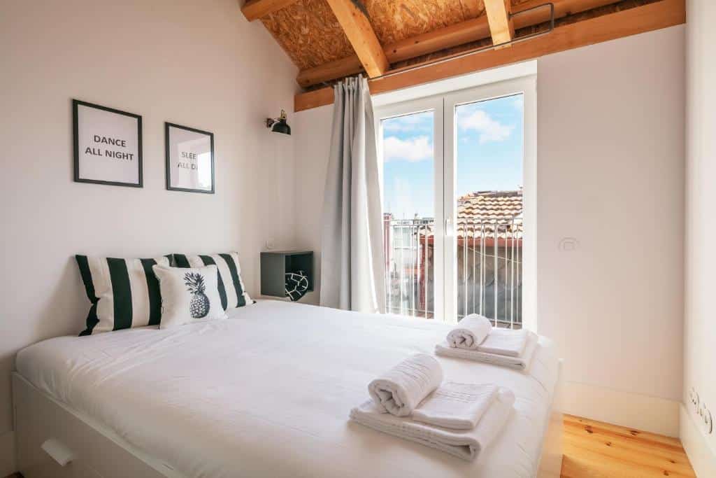 Quarto do Indulge Porto Flats, com cama de casal à esquerda.